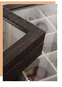 Wooden jewelry box detail showing wood grain texture and velvet divided storage grids.