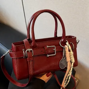 Elegante bolso de hombro retro rojo vino para mujer, bolso casual con hebilla y dijes elegantes.