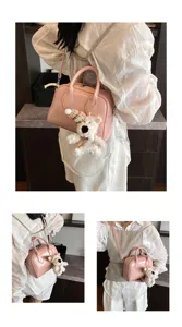 Pink shoulder bag detail showing the sleek glossy finish, compact shape, and cute plush bear charm.