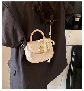 Detalle de bolso de silla beige con textura tejida, ribete de cuero y elegante lazo de encaje.