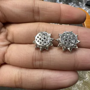 Gros plan détail des composants de bijoux DIY argentés avec des clous de motif de grille.