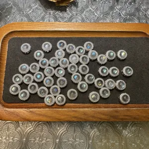 Gros plan detaille de montures de pierres rondes en cuivre micropave pour la creation de bijoux.