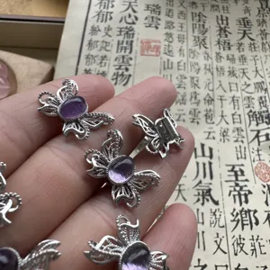 Primo piano dettaglio di accessori per gioielli in argento con farfalla ametista filigrana.