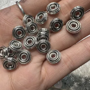 Tibetan silver metal spacer beads for DIY jewelry making, vintage ring shape design, detail view.