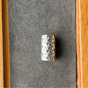 Silver metal woven tube bead accessory for jewelry making, vintage style cylindrical design.
