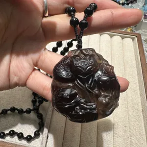 Handcrafted ice obsidian nine-tailed fox pendant necklace close up view, detailed gemstone carving.