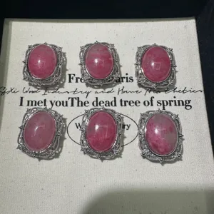 Natural pink stone oval cabochon pendants with vintage silver filigree bezel settings.