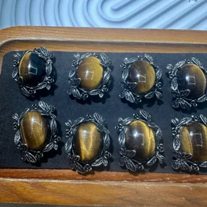 Close-up detail shot of natural yellow tiger eye cabochons with vintage silver frames.