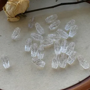 Close-up detailed shot of clear crystal dzi beads displayed on a tray with a dried rose.