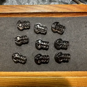 Detailed close-up of natural obsidian fish bone jewelry beads, polished black stone parts.