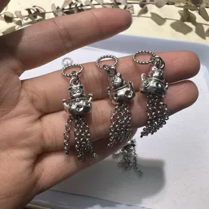 Primo piano di ciondoli gatto portafortuna in argento tibetano con delicate nappe a catena.