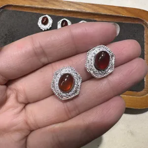 Boucles d'oreilles hexagonales en grenat naturel avec cadre en cristal, détail raffiné.
