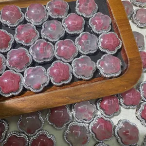 Vista dettagliata di accessori di fiori in pietra rosa con bordo in metallo strass per DIY.