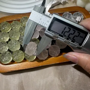 Close-up measurement detail of carved crystal cosmos flower bead, precision sizing display.