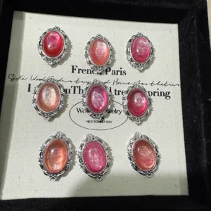 Vista dettagliata di cabochon rosa ovali in rame, accessori per gioielli fai da te.