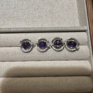 Natural amethyst planet ring detail shot, silver orbit design with sparkling crystal accents.