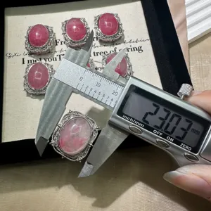 Close-up detail of natural cherry blossom agate gemstone pendant accessory with silver vintage bezel.