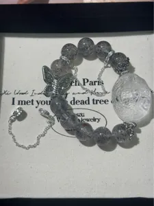 Nahaufnahme des Vintage Perlenarmbands mit Legierung Schmetterling und geschnitztem Stein.