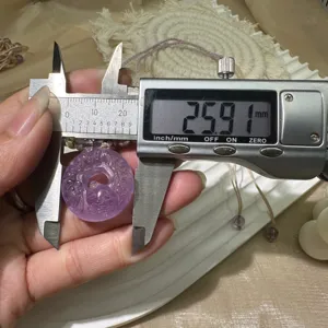 Close-up detail shot of natural amethyst Ping An Kou pendant measured with a digital caliper.