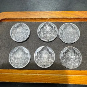 Close-up detail view of carved crystal deity round pendant with top and bottom holes for DIY.