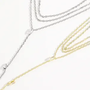 Nahaufnahme von mehrschichtigem Metallketten-Körperschmuck mit funkelnden Kristallakzenten.