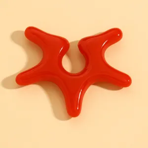 Rotes abstraktes flüssiges Ohrclip Detail, glänzendes sternförmiges Modeschmuckstück.