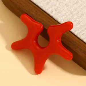 Nahaufnahme des roten flüssigen Ohrclips, glänzende Oberfläche mit avantgardistischem design.