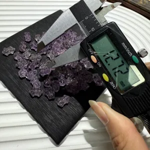 Natural amethyst crystal bear beads detail shot showing size measurement with digital caliper tool.
