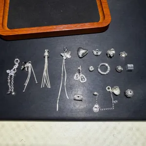 Detail view of various silver alloy DIY jewelry charms, beads and safety chains for bracelets.