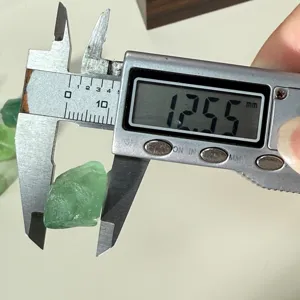 Green fluorite rough stone detail measurement view showing exact size with digital caliper.