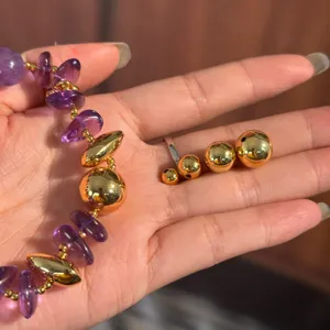 Detailed shot of 18K gold plated smooth spacer beads and purple gemstone bracelet components.