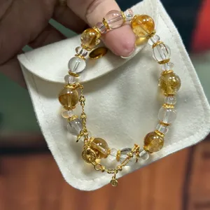 Gold rutilated quartz crystal bracelet detail view showcasing natural yellow stones and gold.