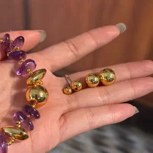 Detailed view of 18K gold plated jewelry spacers and purple crystal beads for DIY crafting.