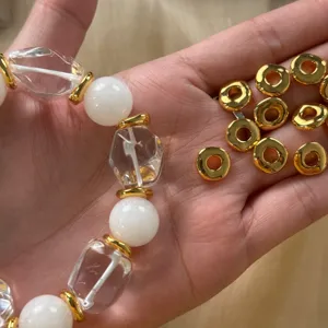Detail view of 18K gold plated geometric openwork spacer beads and crystal bracelet components.