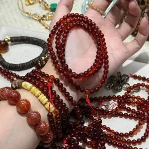 Close-up detail of multi-loop red garnet gemstone bead bracelets on hand, natural crystal jewelry.