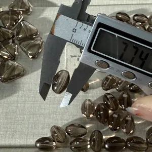 Smoky quartz olive beads detail shot showing precise size measurement with digital caliper tool.