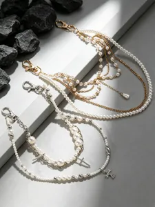 Meerlaagse parel en metalen kruis broekketting subcultuur streetwear mode accessoire.