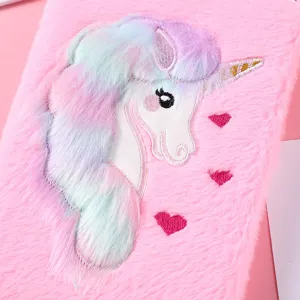 Close-up of pink plush unicorn notebook with colorful mane and embroidery. Detail view.