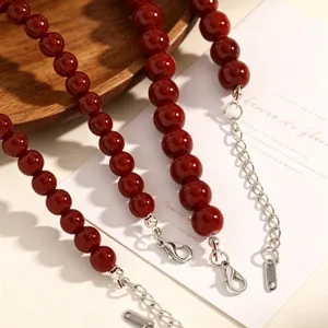 Vue detaillee de la chaine de clavicule de perles de verre bordeaux retro avec chaine d'ext.
