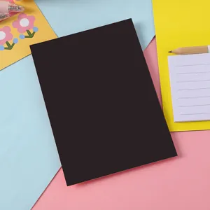 Minimalist black cover portable notepad with colorful stationery background setup for daily use.