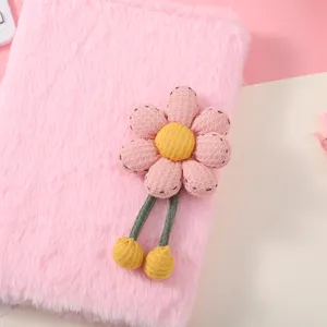Primo piano dettagliato di un taccuino in peluche rosa con decorazione di fiore 3D.