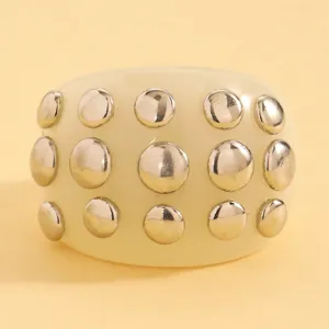 Close-up of a wide resin cuff bracelet featuring metallic domed stud details in punk style.