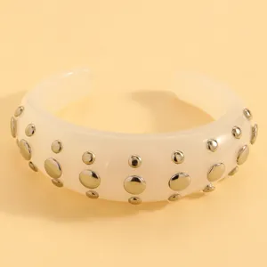 Resin cuff bracelet detail, beige open bangle with silver metal rivet studs for punk style.