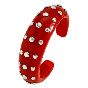 Red resin cuff bracelet with metal dot studs, punk style open bangle for women daily wear.