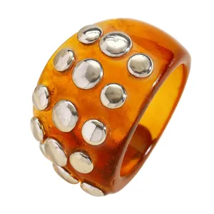 Chunky resin ring with amber stain and silver metal rivets, punk fashion statement jewelry piece.