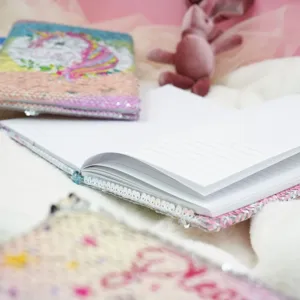Detailed close-up view of cute sequin notebook with lined pages and colorful unicorn cover.