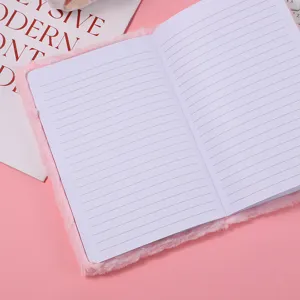 Carnet pelucheux rose en vue de détail ouverte avec pages lignées propres et couverture douce.