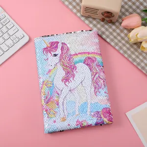 Detailansicht des niedlichen Cartoon-Einhorn-Pailletten-Notizbuchcovers und Regenbogenmusters.