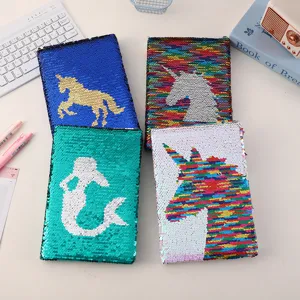 Close-up of reversible sequin notebooks featuring colorful unicorn and mermaid designs.