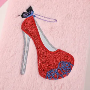 Pink plush notebook cover detail featuring sparkling red sequin high heel shoe embroidery.